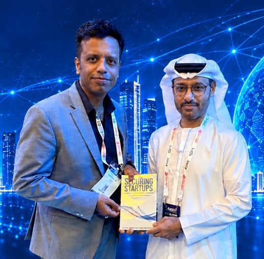 Sanil Nadkarni with His Excellency Al Kuwaiti holding a copy of Securing Startups